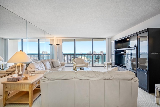 living room featuring light carpet, a textured ceiling, and floor to ceiling windows