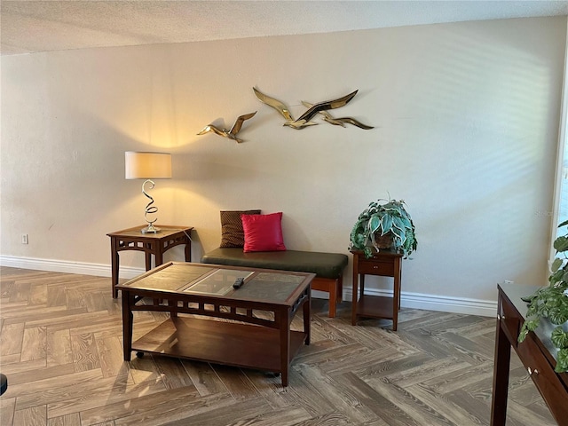 sitting room with dark parquet flooring and a textured ceiling