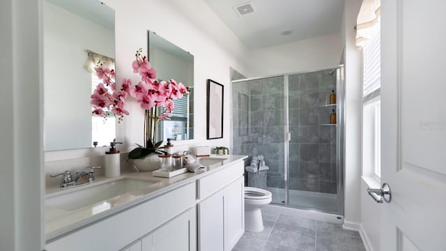 bathroom with tile patterned flooring, a shower with door, vanity, and toilet