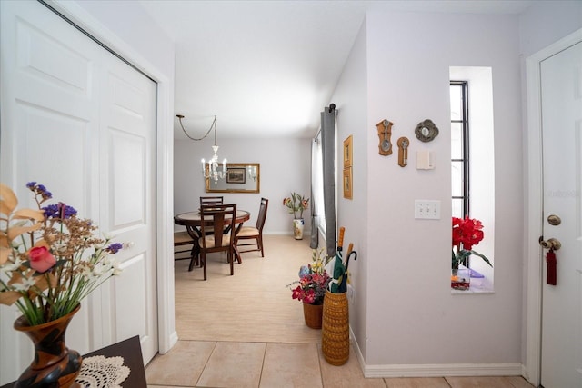 hall featuring a notable chandelier and light tile patterned flooring