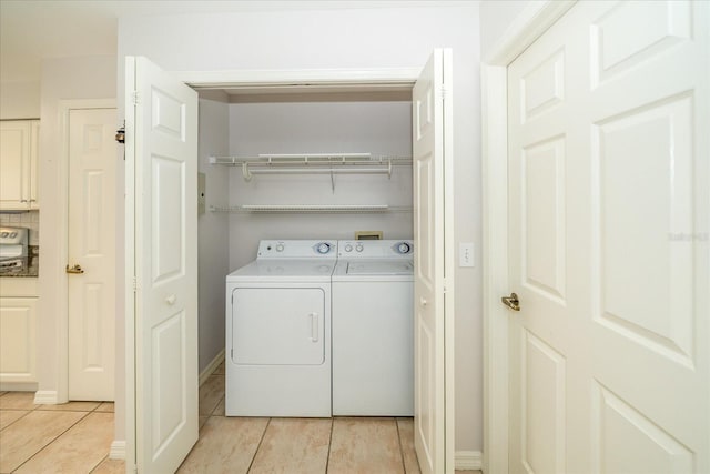 clothes washing area with light tile patterned flooring and washing machine and clothes dryer