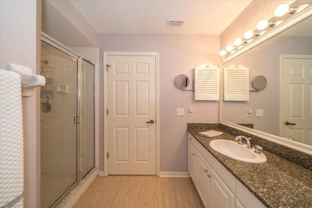 bathroom featuring a shower with door, vanity, and wood-type flooring