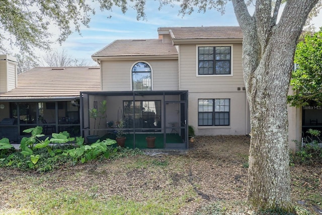 rear view of property featuring a sunroom