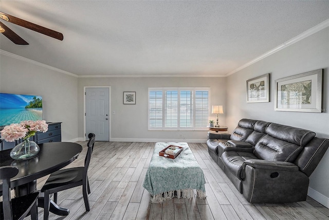 living room with crown molding, ceiling fan, a textured ceiling, and light wood-type flooring