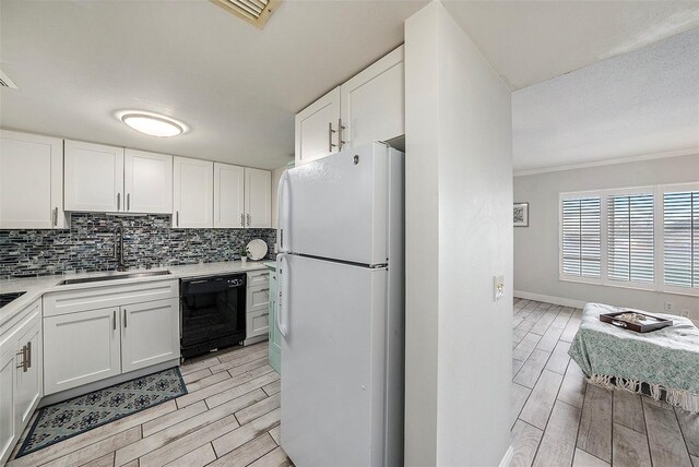 kitchen with white cabinetry, sink, black dishwasher, and white refrigerator