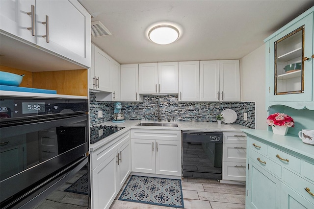 kitchen featuring black appliances, backsplash, white cabinetry, and sink