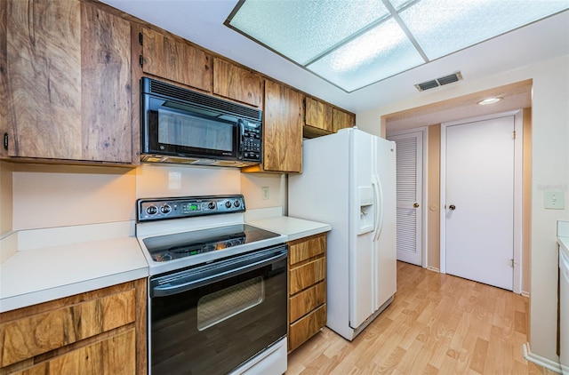 kitchen with electric range oven, light wood-type flooring, and white fridge with ice dispenser