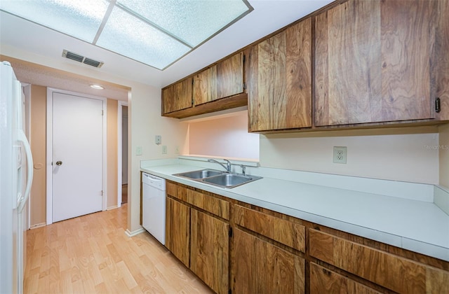 kitchen featuring sink, light hardwood / wood-style floors, and white appliances