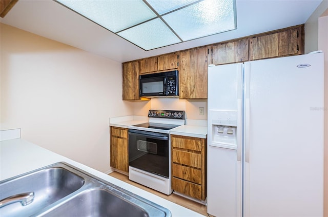 kitchen featuring white appliances and sink