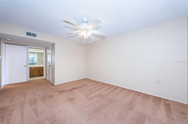 carpeted empty room featuring ceiling fan and a textured ceiling