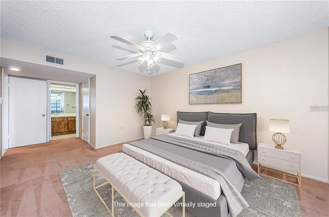 bedroom featuring carpet flooring, connected bathroom, ceiling fan, and a textured ceiling