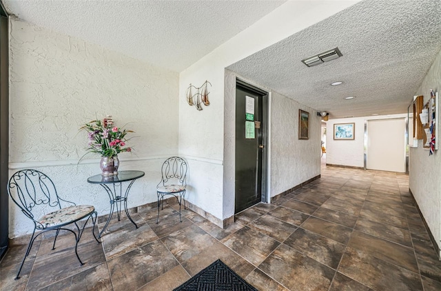 hallway with a textured ceiling