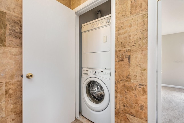 washroom featuring carpet and stacked washer / dryer