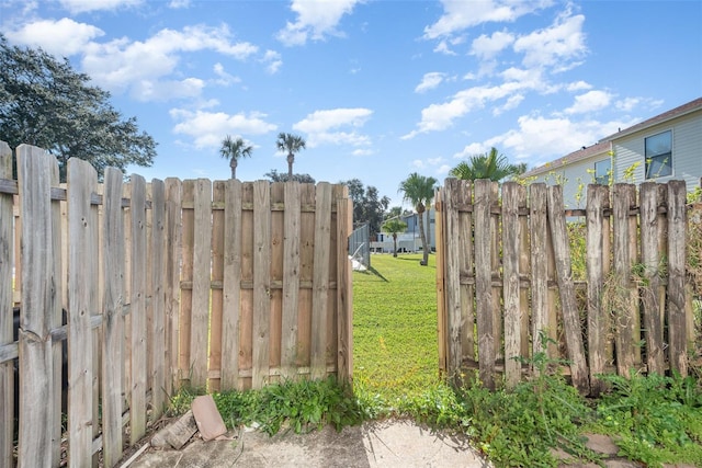 view of gate featuring a lawn