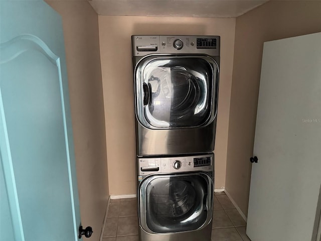 laundry room featuring light tile patterned floors and stacked washer / drying machine