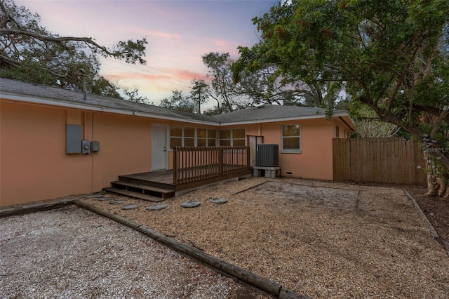 back house at dusk featuring a deck