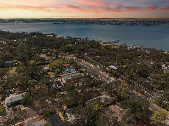 aerial view at dusk featuring a water view