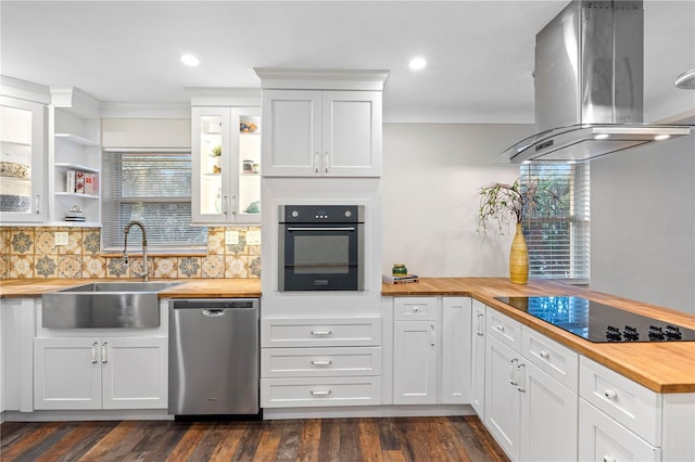 kitchen with island range hood, white cabinetry, stainless steel appliances, and wooden counters