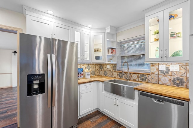 kitchen with butcher block counters, white cabinetry, sink, and stainless steel appliances