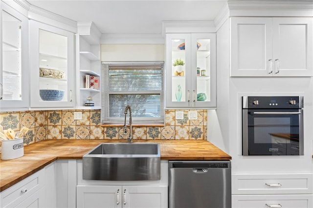 kitchen with wood counters, sink, decorative backsplash, white cabinetry, and stainless steel appliances