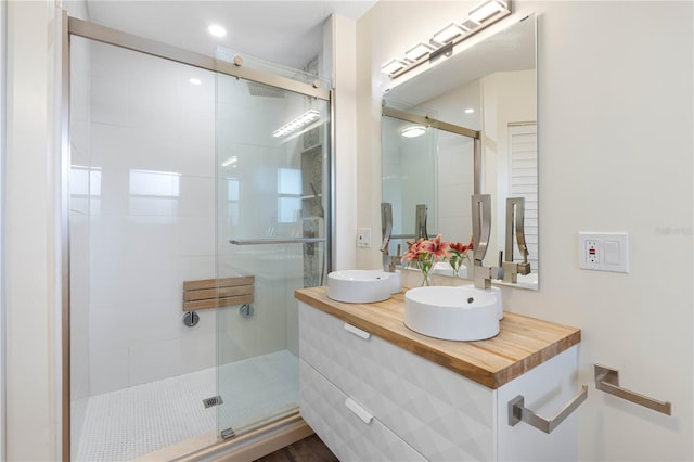 bathroom with vanity and a shower with door