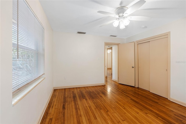 unfurnished bedroom with hardwood / wood-style flooring, ceiling fan, and a closet