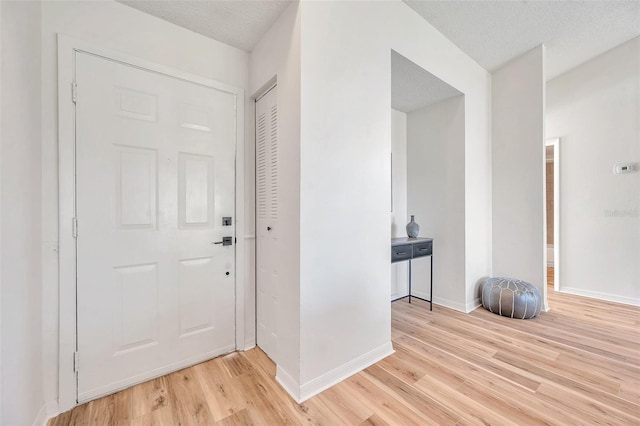 foyer featuring a textured ceiling and light wood-type flooring