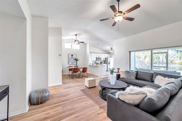 living room with sink, lofted ceiling, and light wood-type flooring