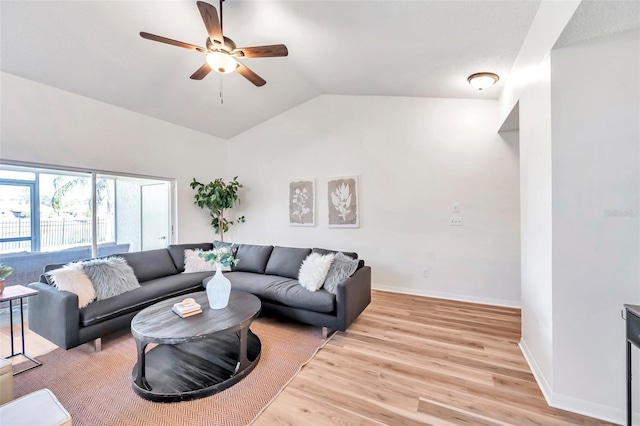 living room featuring ceiling fan, light hardwood / wood-style floors, and vaulted ceiling