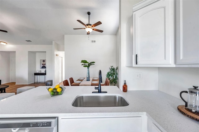 kitchen with white cabinets, dishwasher, light stone counters, and sink