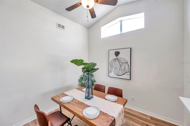 dining room featuring ceiling fan, light hardwood / wood-style flooring, and vaulted ceiling