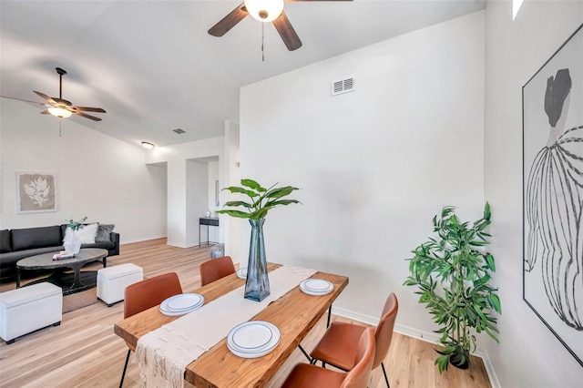 dining area featuring lofted ceiling and light hardwood / wood-style flooring