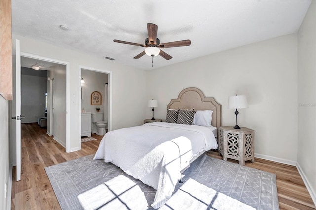 bedroom featuring connected bathroom, ceiling fan, hardwood / wood-style floors, and a textured ceiling