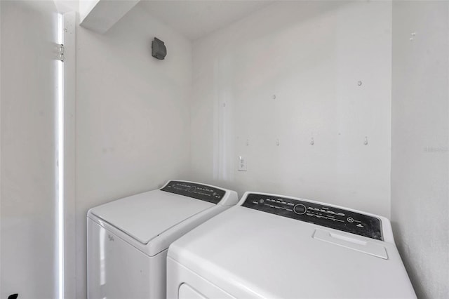 clothes washing area featuring separate washer and dryer