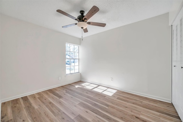 unfurnished room featuring a textured ceiling, light wood-type flooring, and ceiling fan