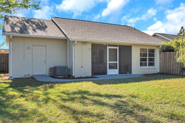 rear view of house featuring a yard and central air condition unit