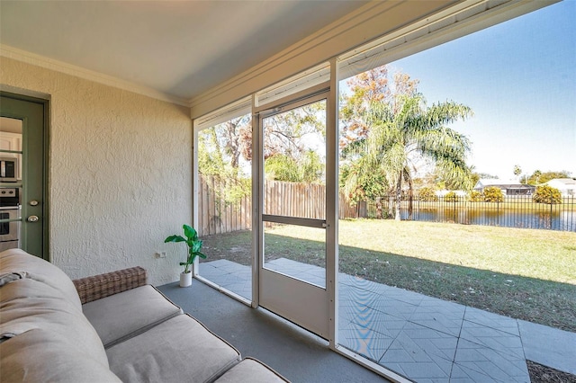 sunroom featuring a water view