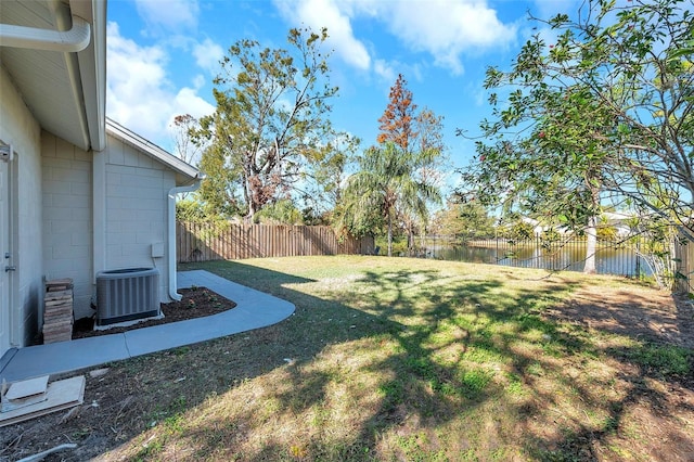 view of yard with a water view and central air condition unit