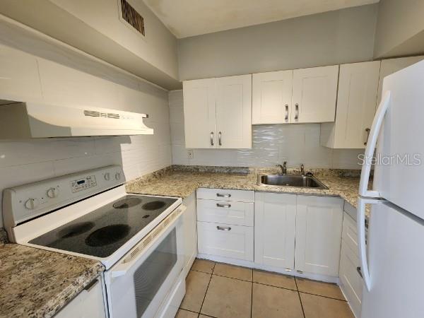 kitchen featuring white cabinets, white appliances, sink, and exhaust hood