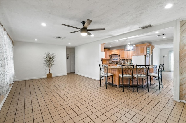 dining area with ceiling fan and a textured ceiling