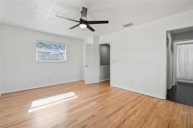 interior space featuring a textured ceiling, light hardwood / wood-style floors, and ceiling fan