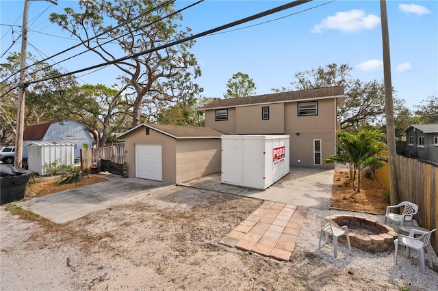 view of front of house with an outbuilding, a garage, and an outdoor fire pit