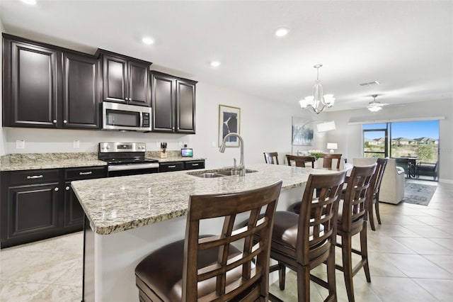 kitchen featuring appliances with stainless steel finishes, a kitchen island with sink, a kitchen breakfast bar, and sink