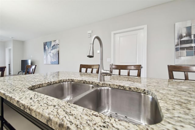 kitchen with light stone counters and sink