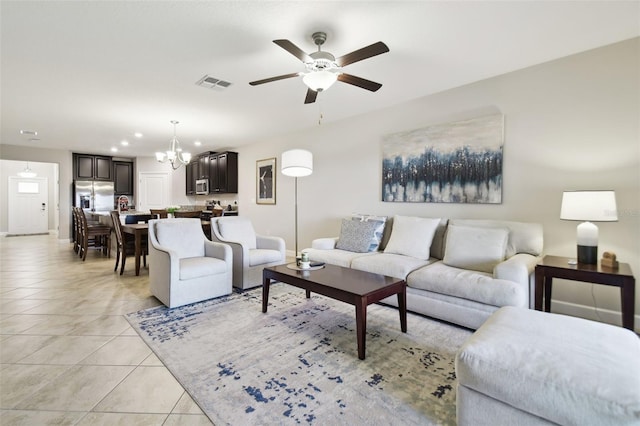 living room featuring ceiling fan with notable chandelier and light tile patterned flooring