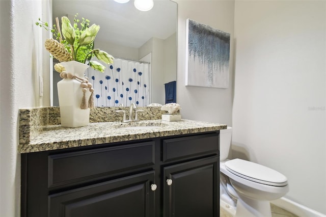 bathroom featuring vanity, curtained shower, and toilet