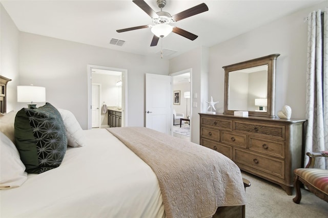 carpeted bedroom with ceiling fan and ensuite bath