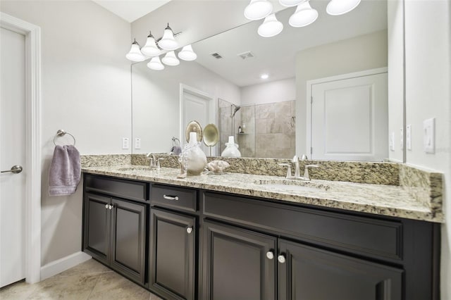 bathroom with tile patterned flooring, vanity, and walk in shower