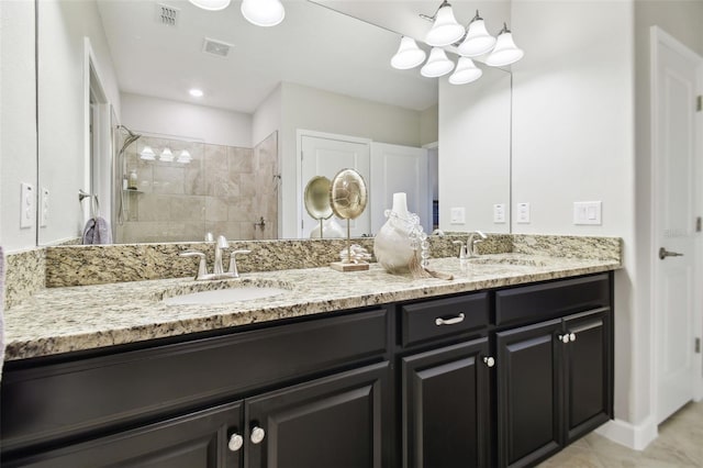 bathroom featuring tiled shower, vanity, and tile patterned floors