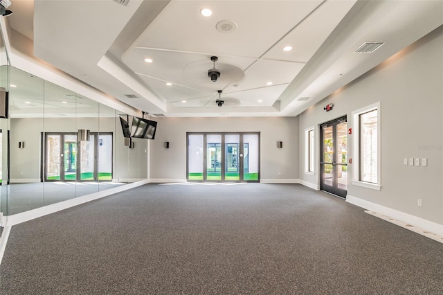 spare room featuring a tray ceiling, a wealth of natural light, and ceiling fan